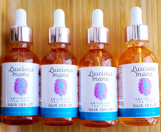 Photo of 4 orange bottles with white labels with a purple and blue lions that says luscious mane rosemary Tea Tree hair serum.