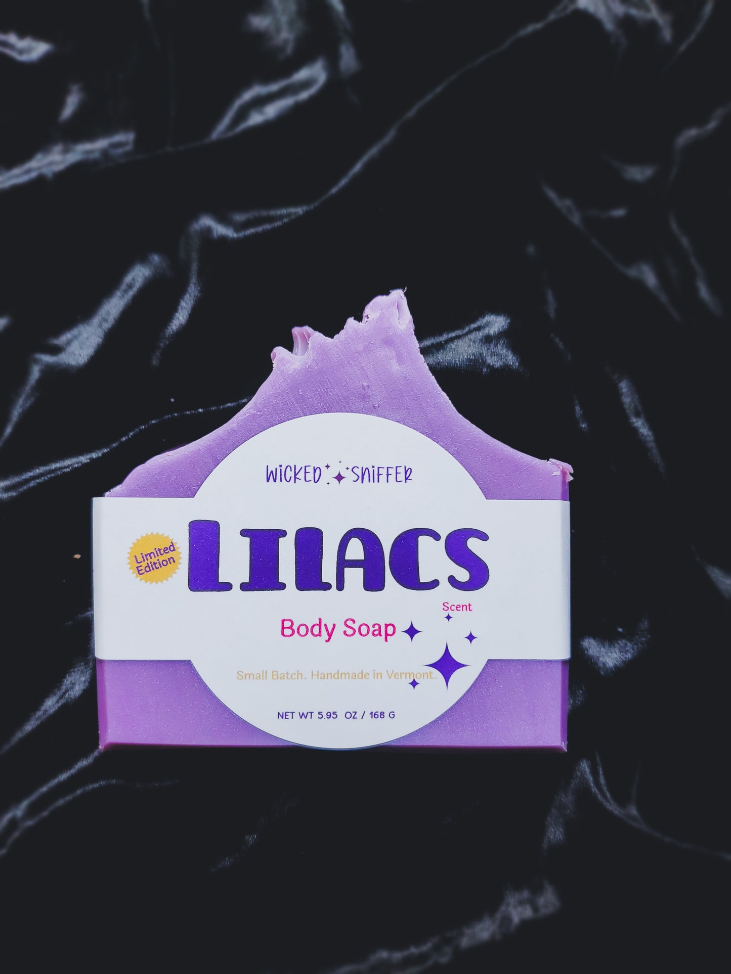 Purple body soap bar with 'Lilacs' scent on a black background
