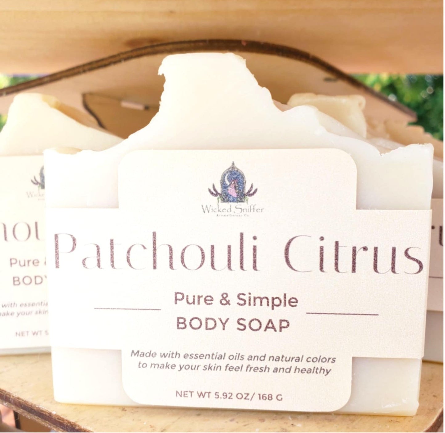 Patchouli Citrus body soap with a label on a wooden surface