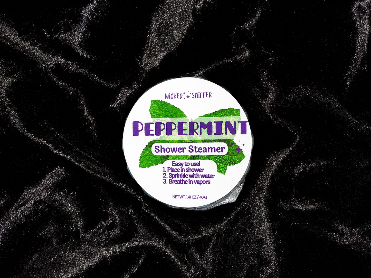 Peppermint shower steamer with label on a black textured background