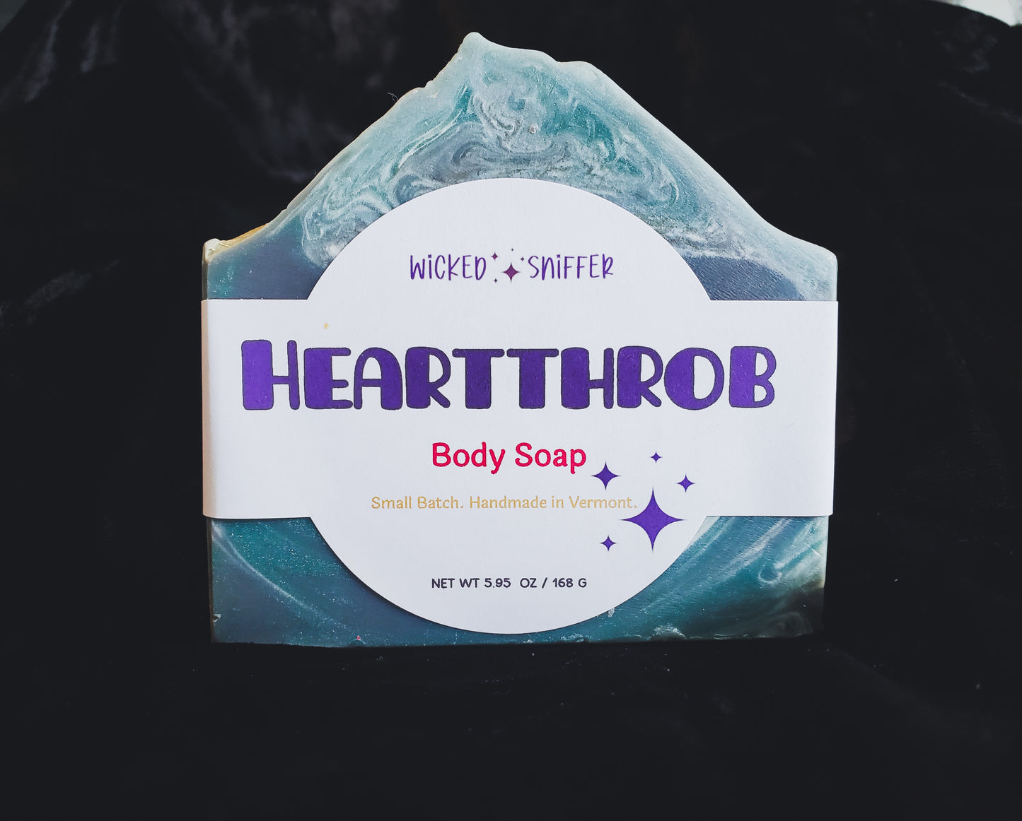 Bar of handmade blue Heartthrob cold process soap on a dark background made in Vermont