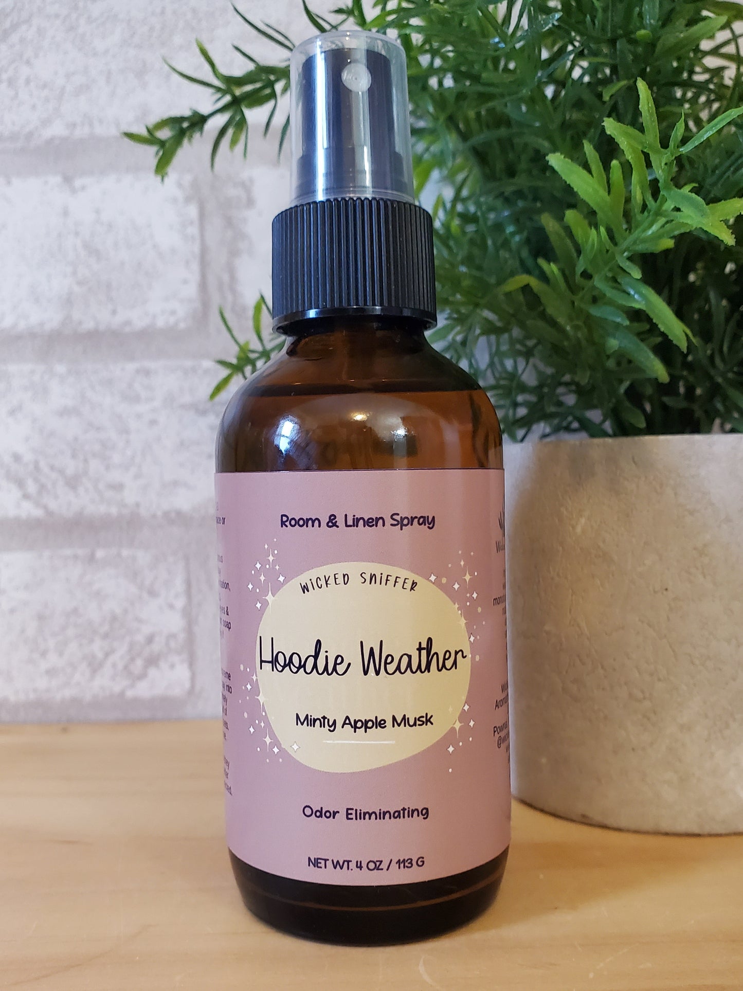 Bottle of room spray with a label on a wooden surface