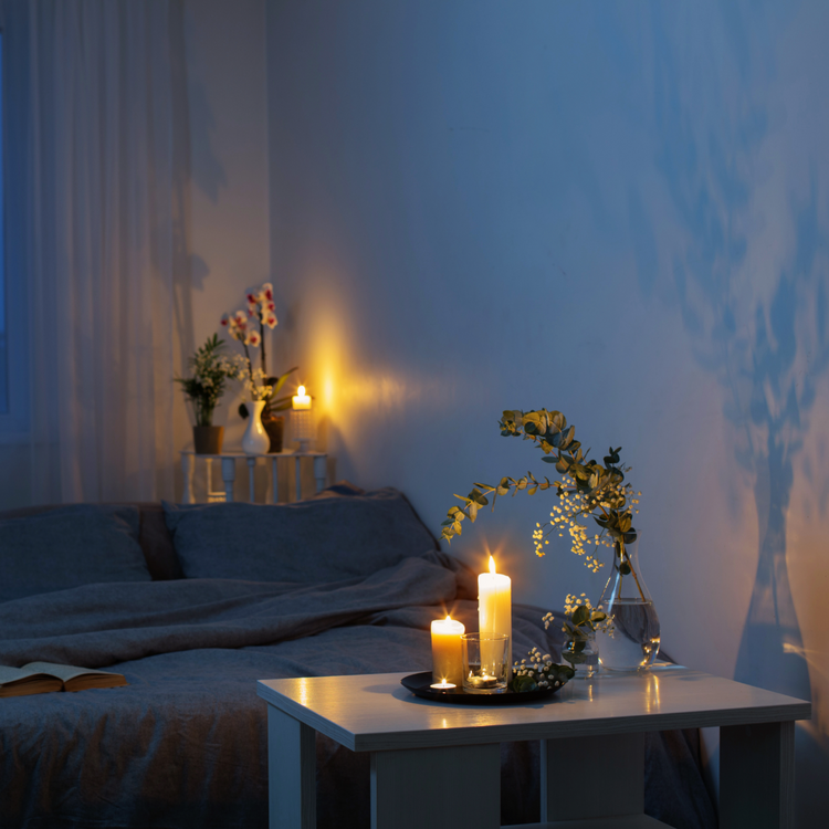 candle in a dim room with blue gray walls.
