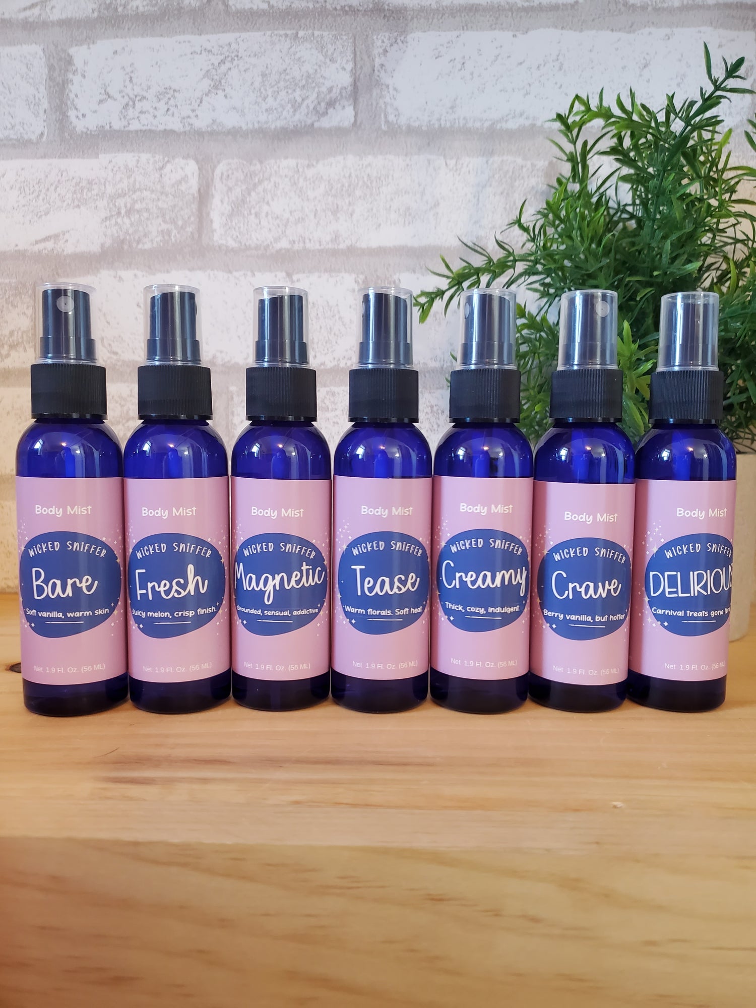 A row of blue bottles with pink labels on a wood surface.
