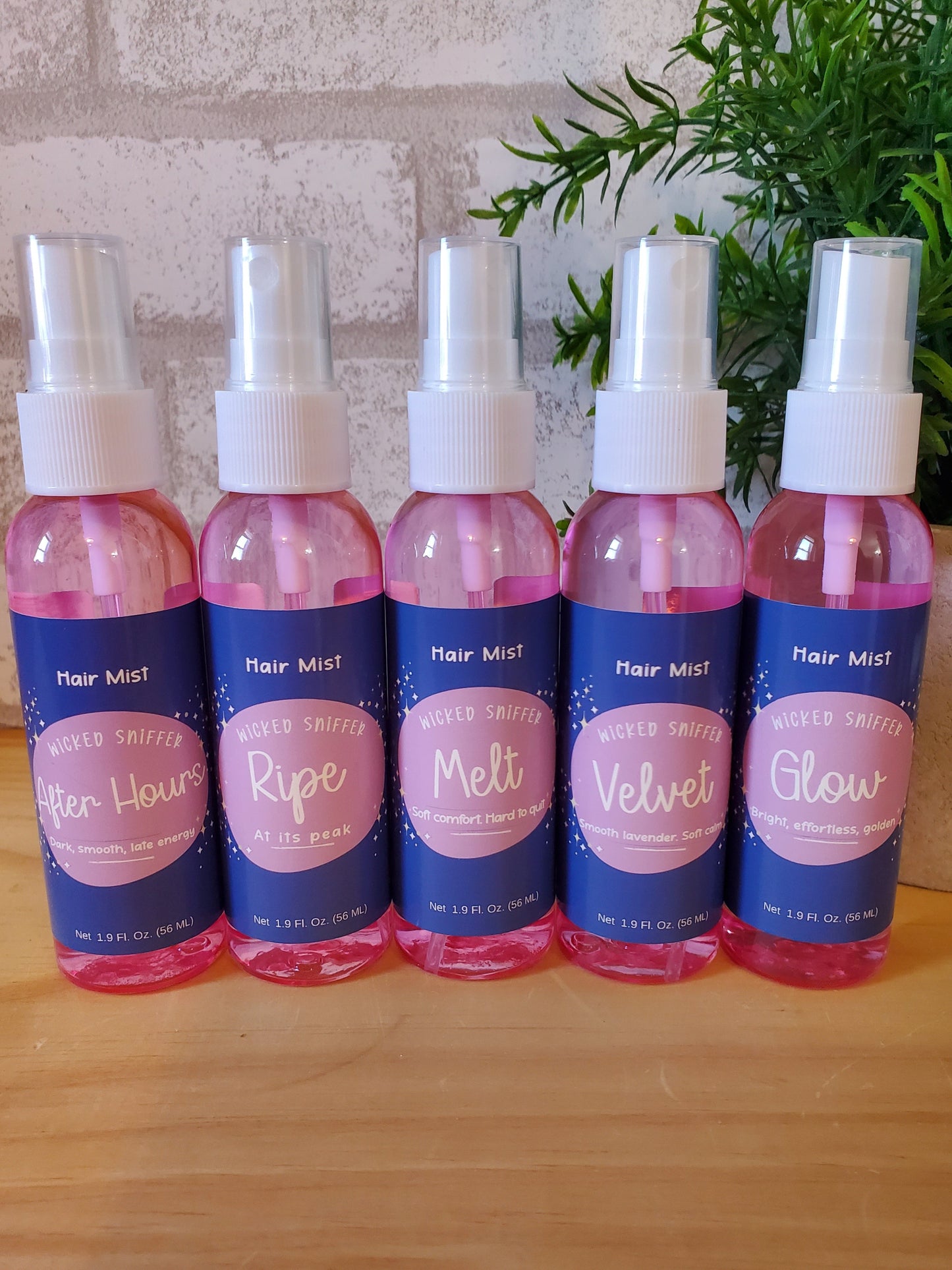 Set of hair mist bottles with visible labels on a wooden surface.