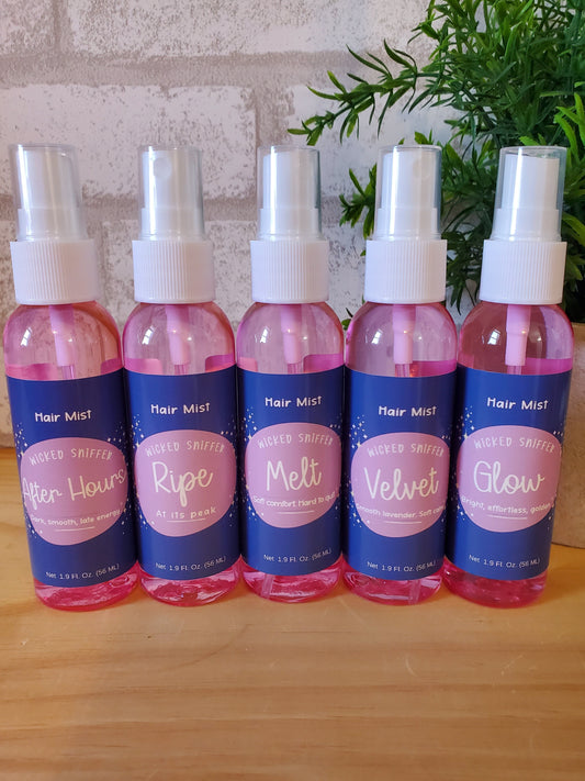 Set of hair mist bottles with visible labels on a wooden surface.