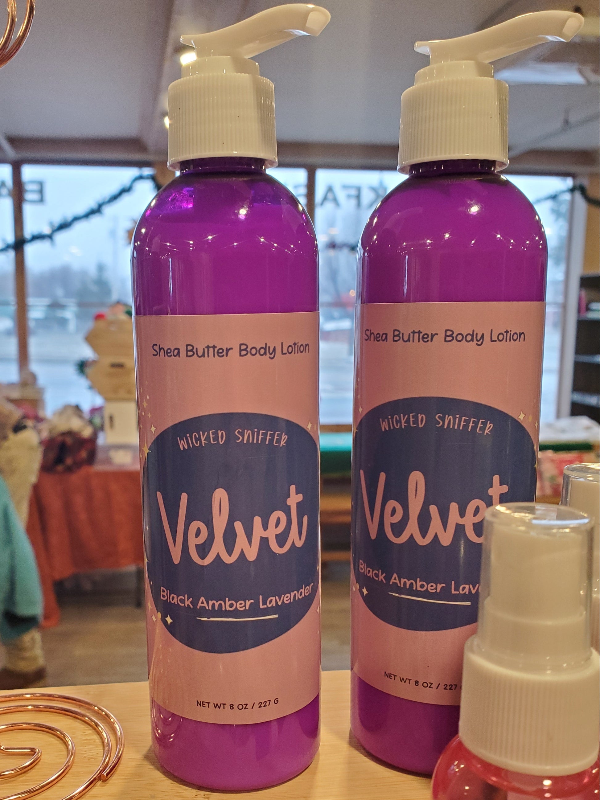 Purple bottle of lotion on a wood surface.