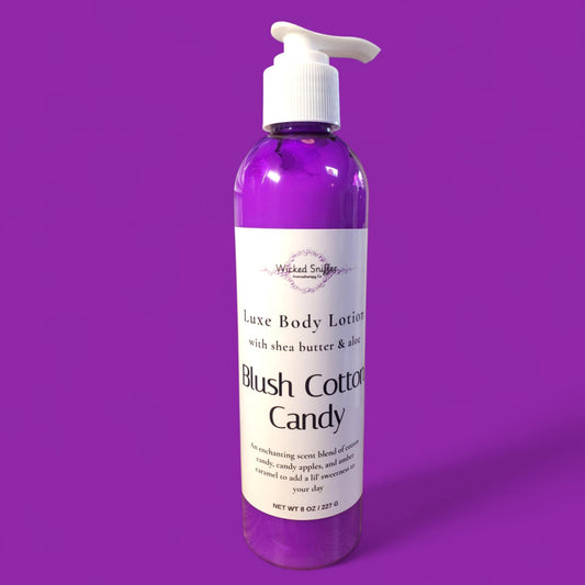 Bottle of 'Blush Cotton Candy' body lotion on a purple background