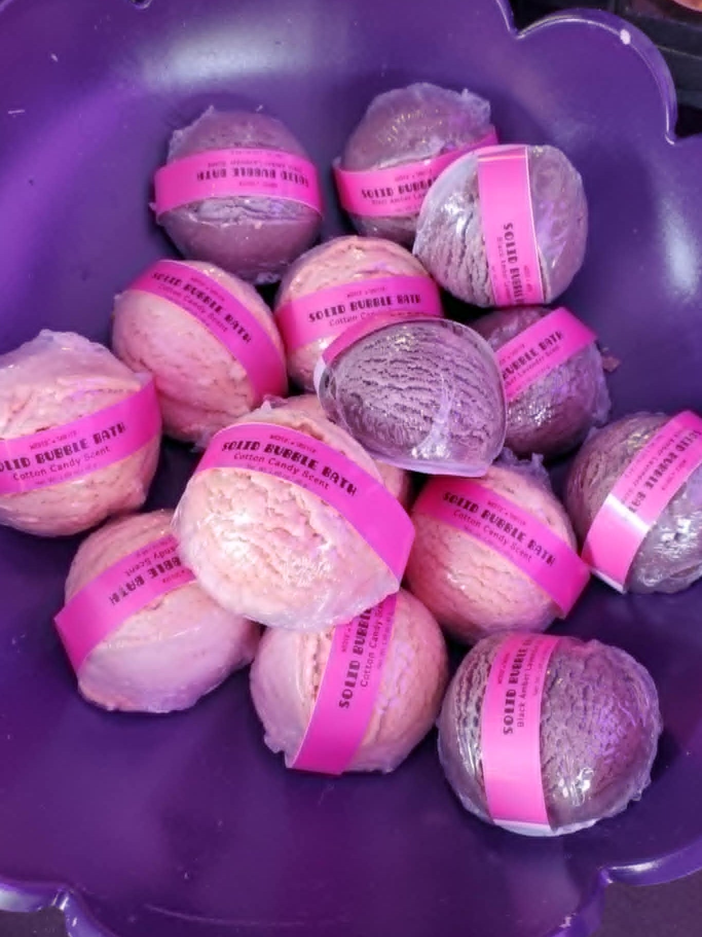 Purple bowl filled with pink and purple bubble bath with visible labels.