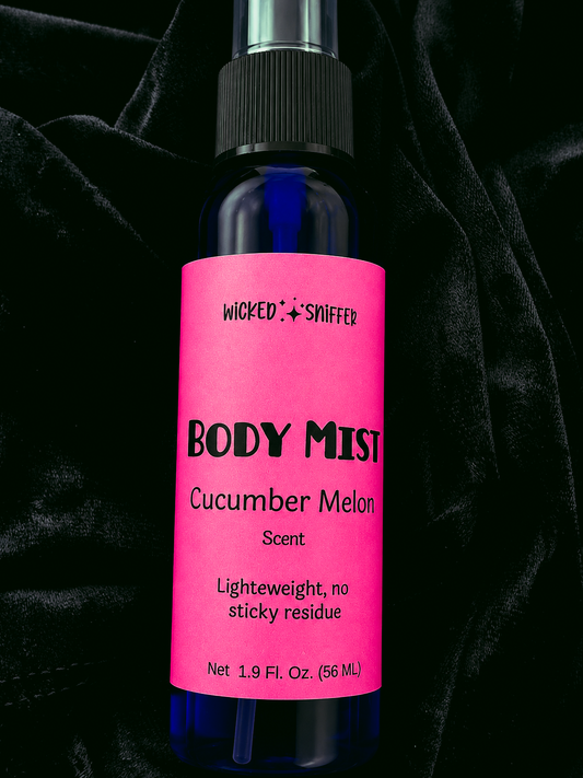 Body mist bottle with pink label on a dark background