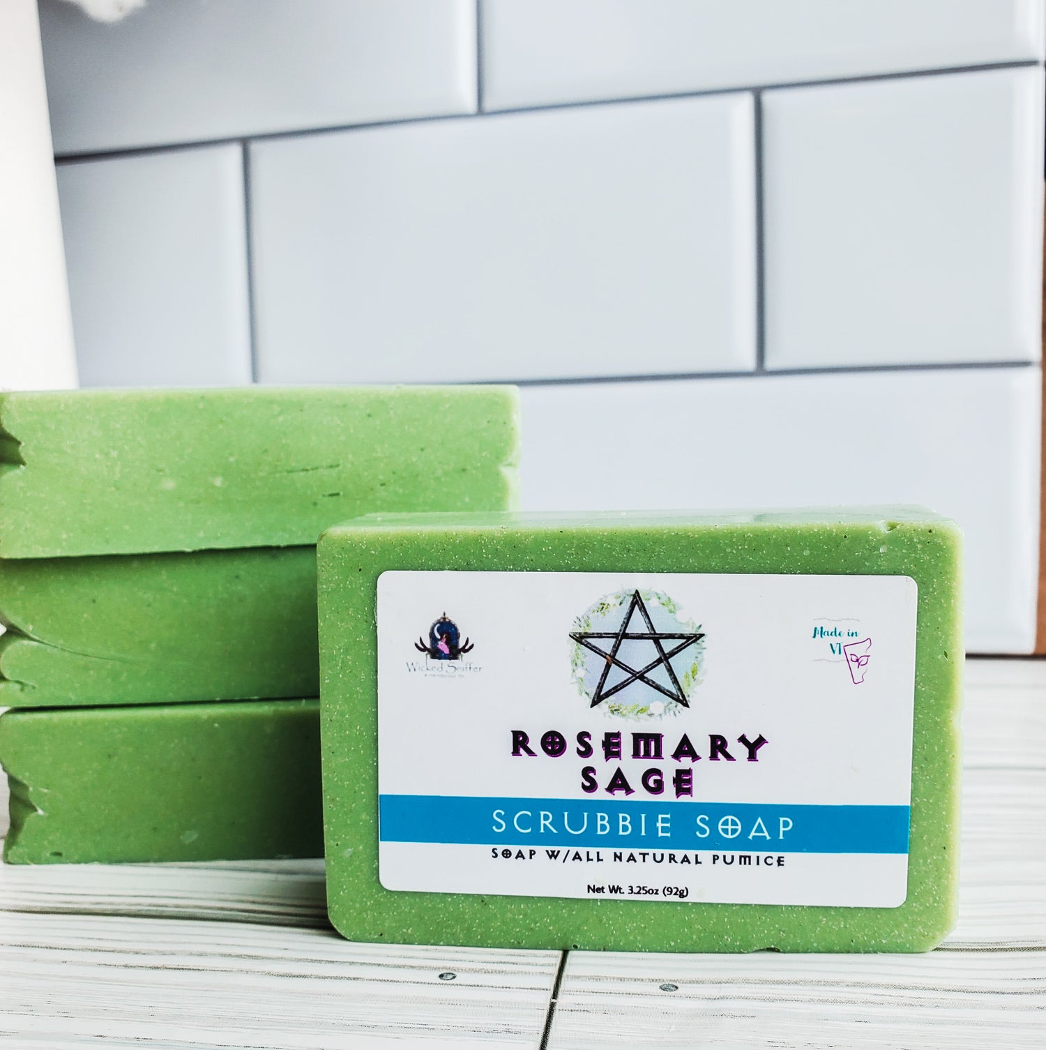 Picture of 4 green bars of soap with a white rectangular label with a pentagram.