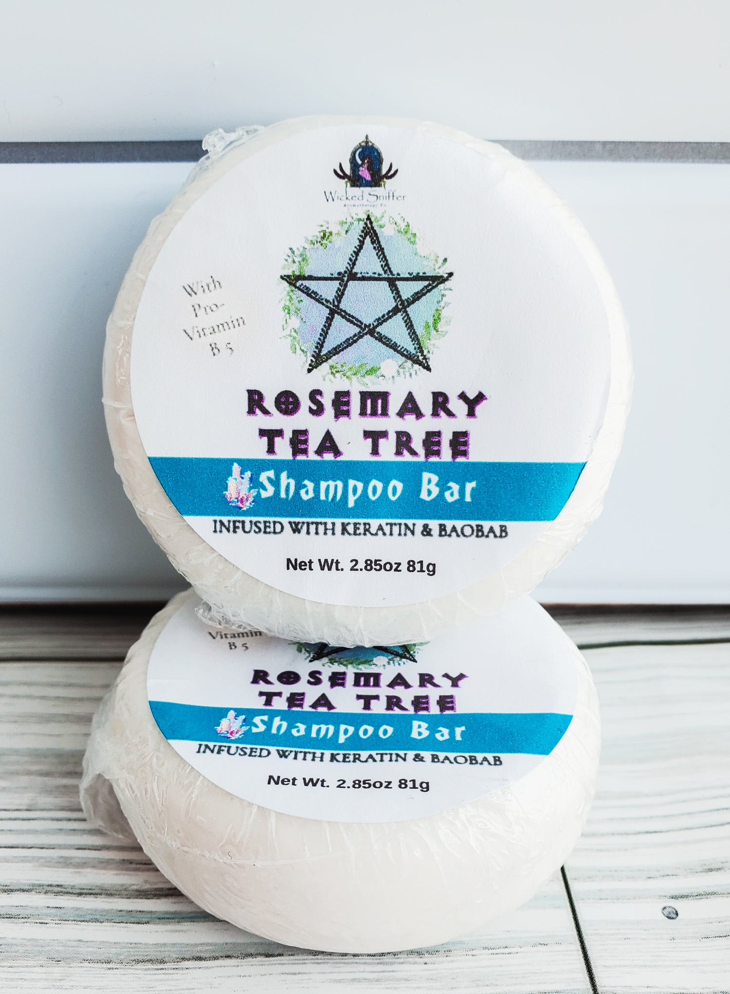 Photo of two round solid shampoo bars with white round labels, a blue band and pentagram.