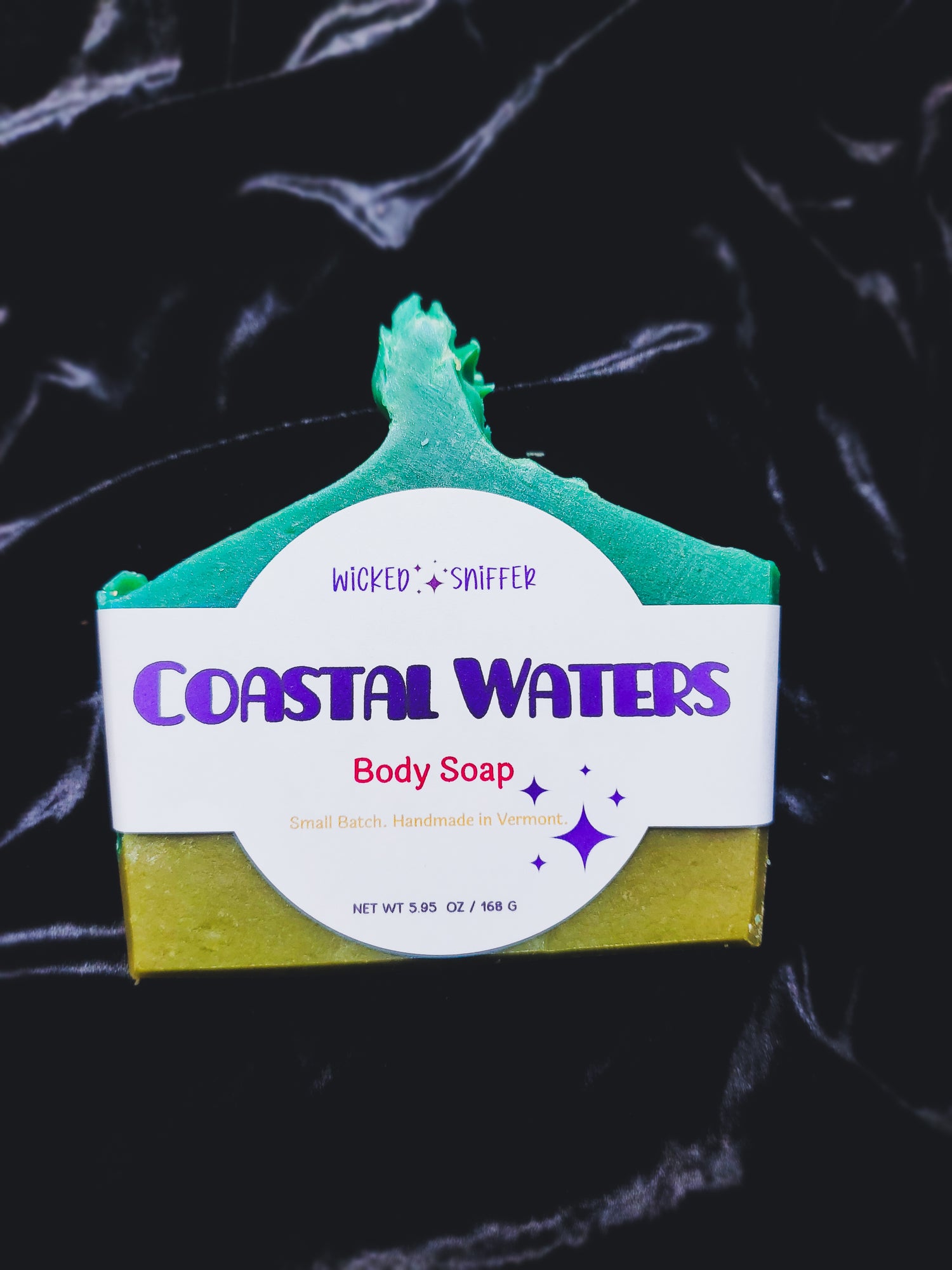 Bar of soap with 'Coastal Waters' label on a dark background