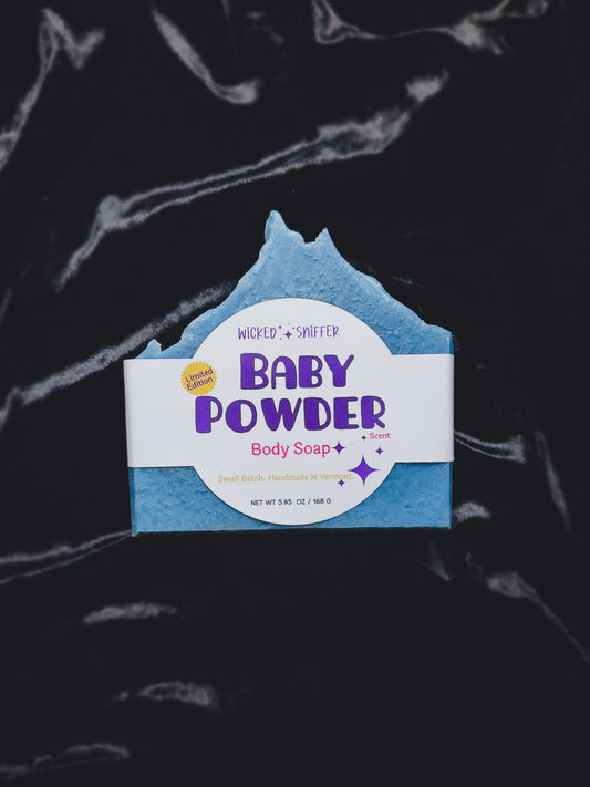 Blue baby powder body soap bar with a label on a dark background