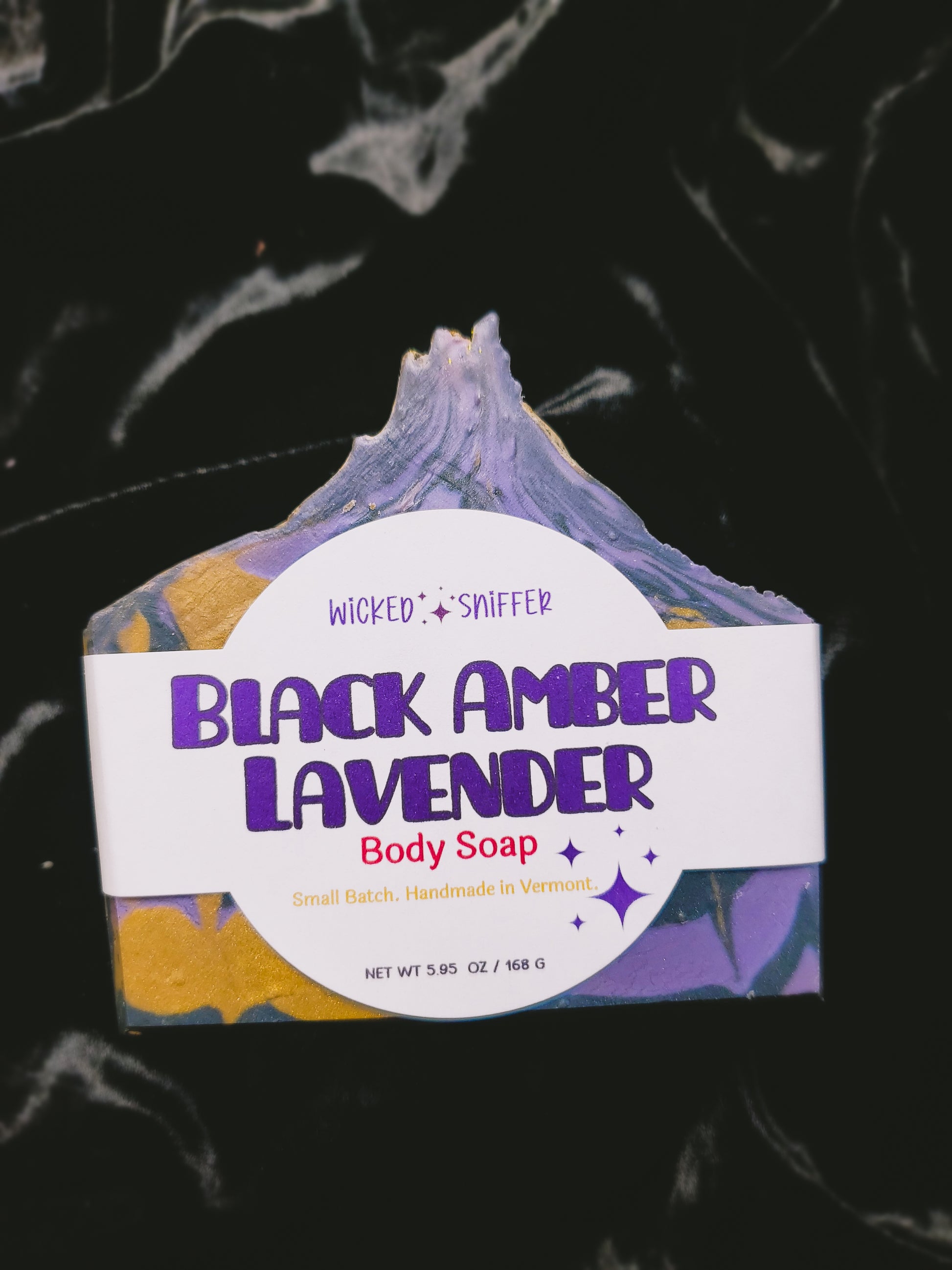 Bar of soap with 'Black Amber Lavender' label on a dark background
