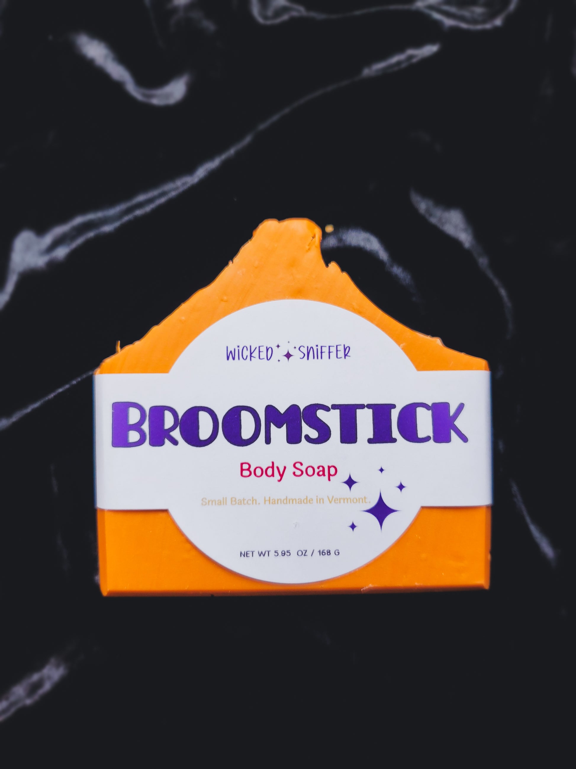 Bar of soap with 'Wicked Sniffer Broomstick' branding on a dark background