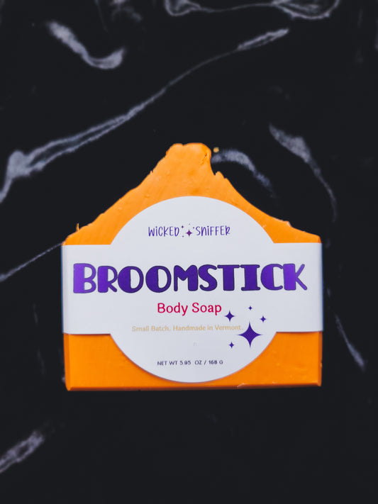 Bar of soap with 'Wicked Sniffer Broomstick' branding on a dark background