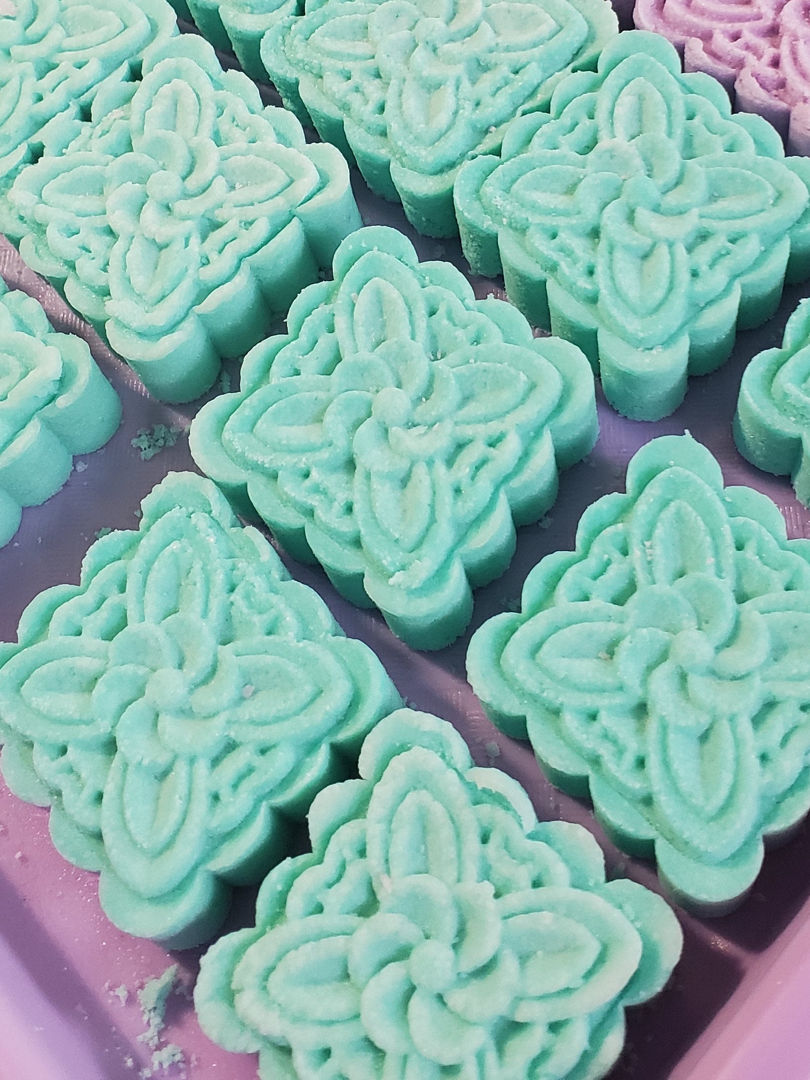 Green shower steamers in a pink tray.