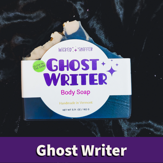 A bar of Ghost Writer body soap with a white wrapper, displayed on a black velvet background with a purple banner at the bottom reading 'Ghost Writer'.