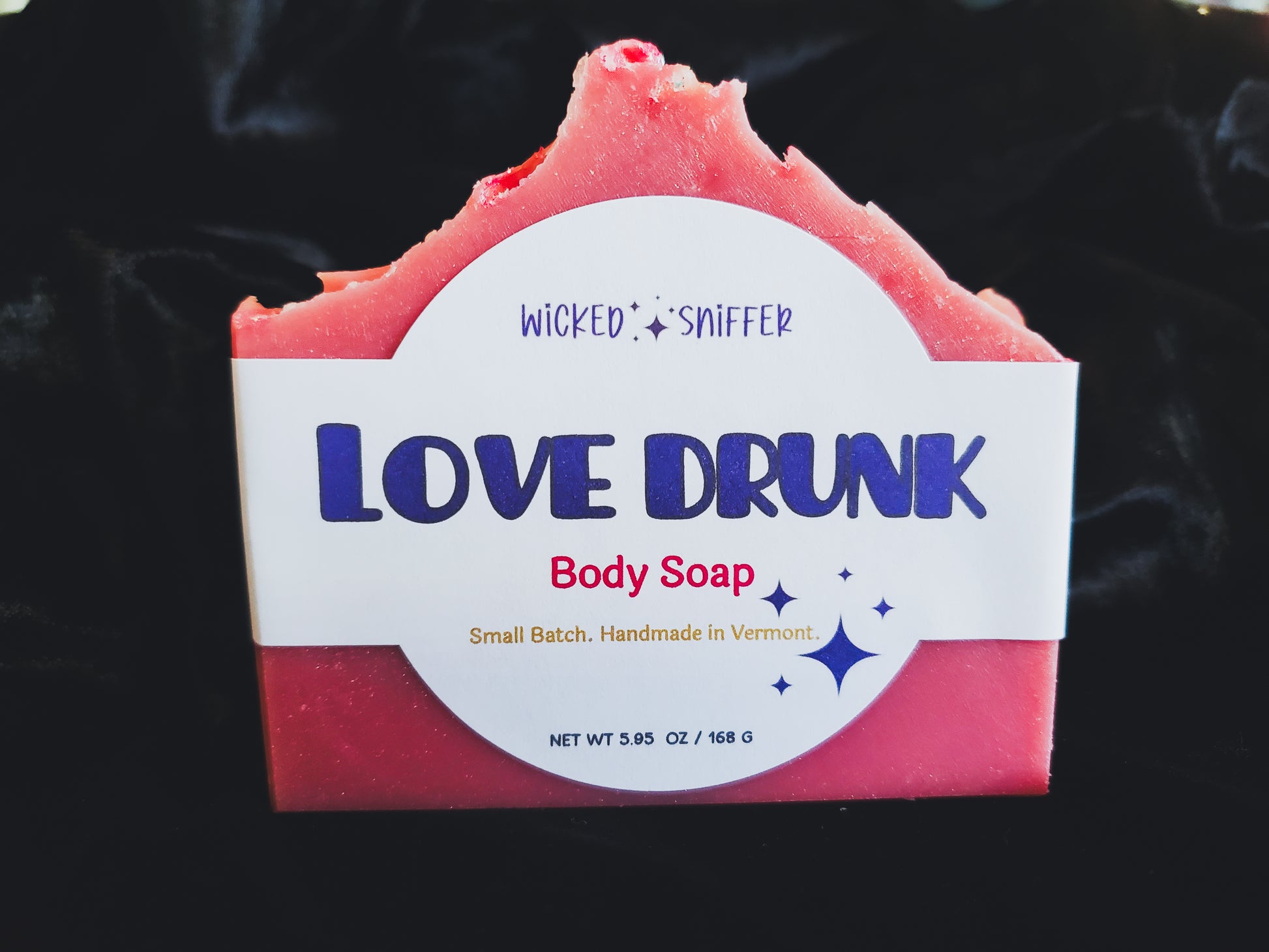 Bar of handmade pink Love Drunk cold process soap  on a dark background made in Vermont 