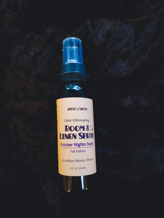 a black bottle on a black velvet background with a tan label and black and purple lettering. 