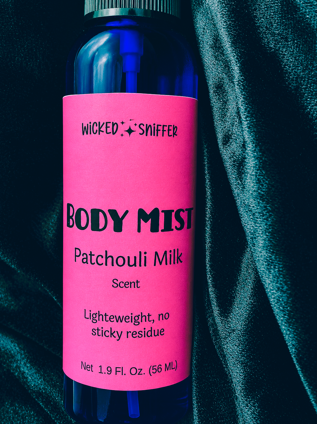 Body mist bottle with pink label and blue cap on a dark background