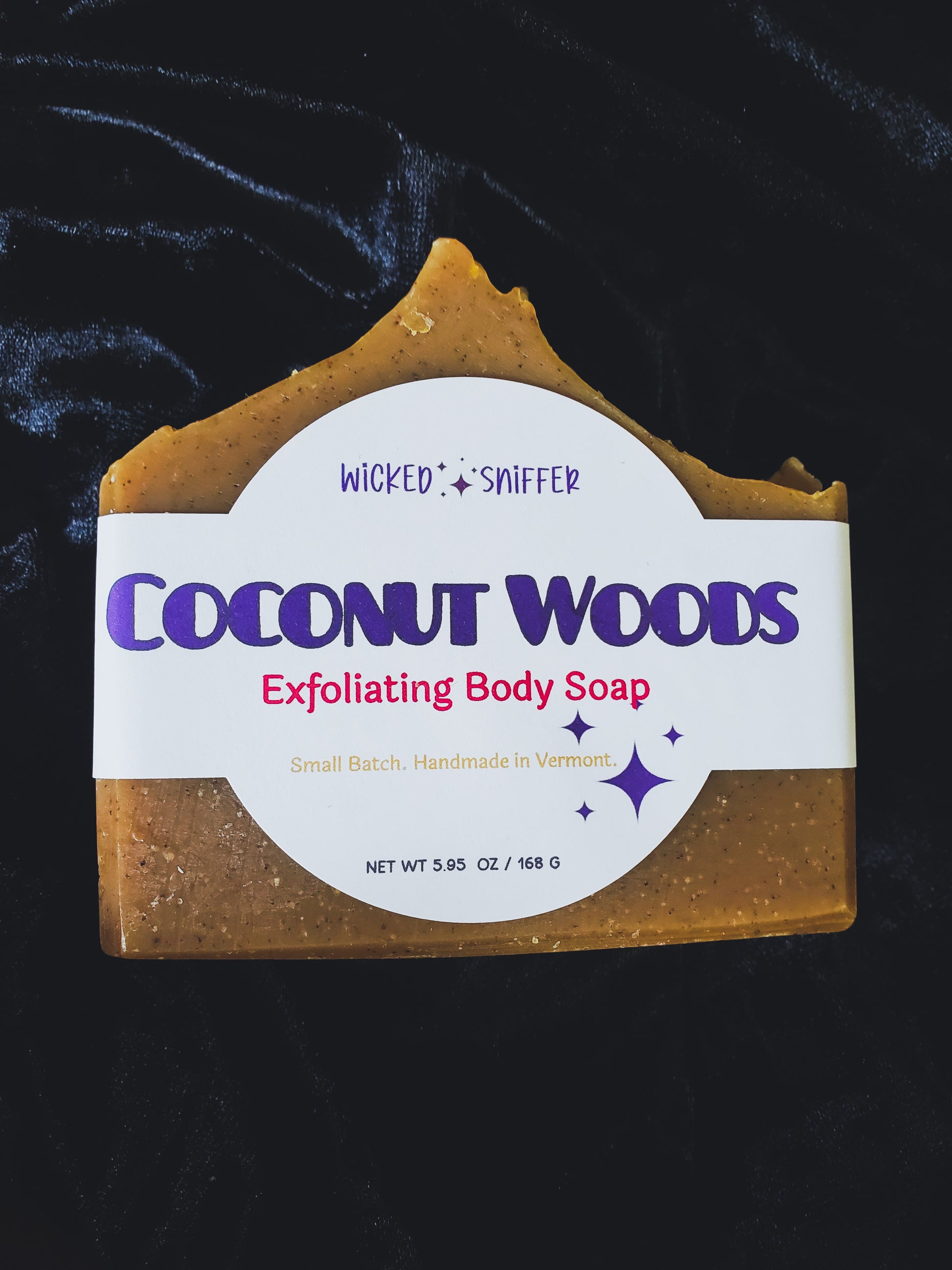 Bar of handmade Coconut Woods cold process soap  on a dark background made in Vermont 