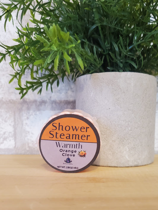 Shower steamer with a plant and wooden surface in the background