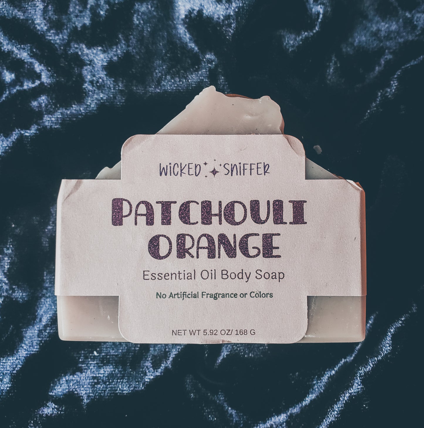 Tan bar of patchouli orange soap on a black background