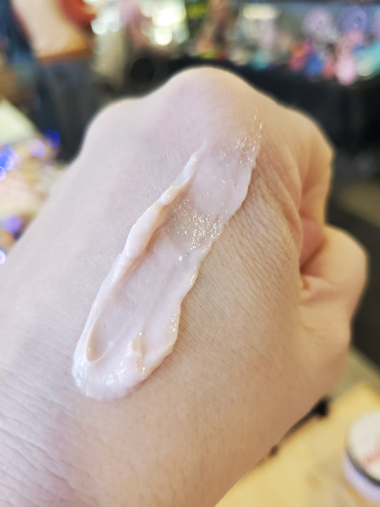 Hand applying a cream substance on skin with a blurred background