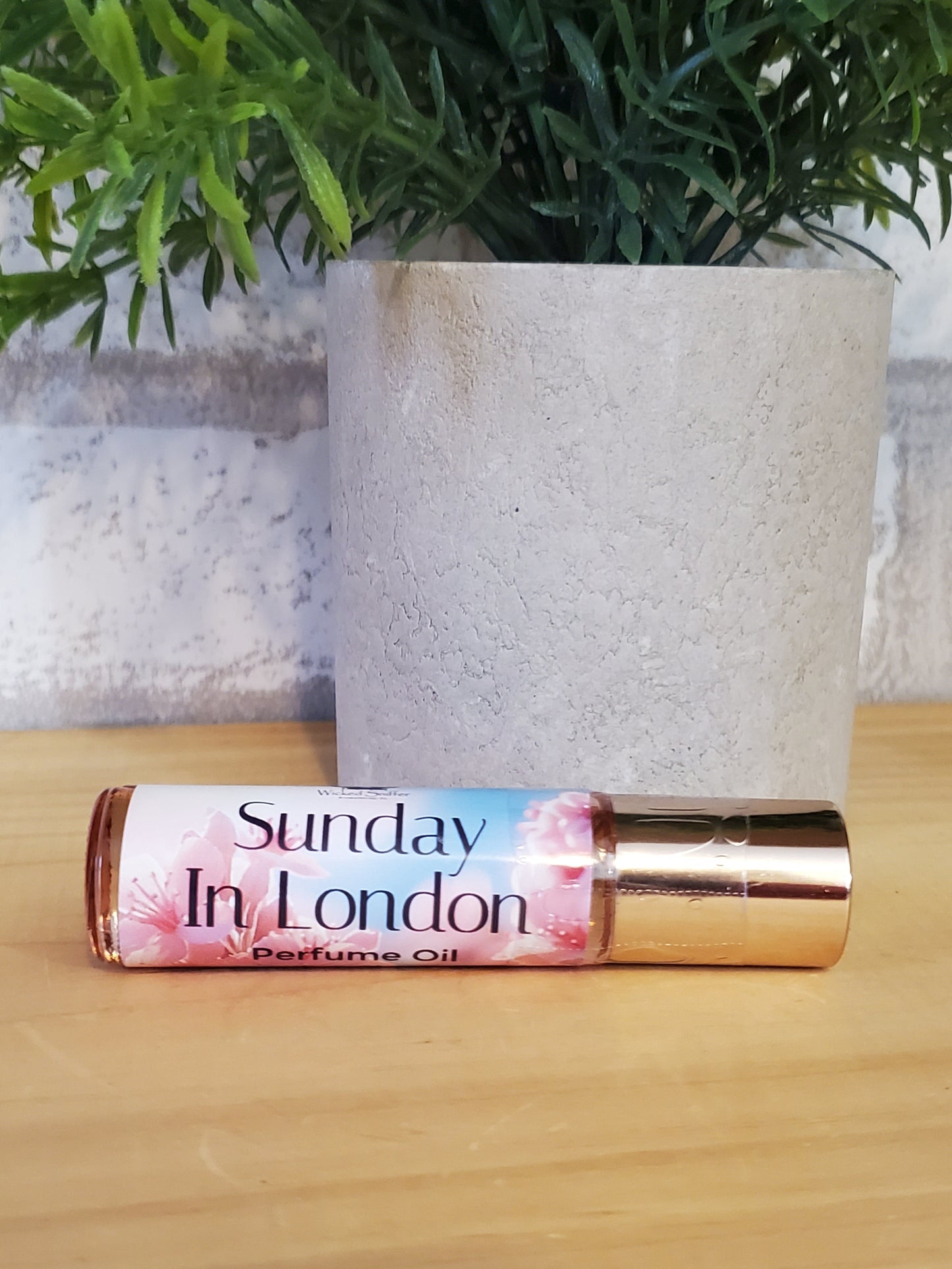 Roll-on perfume bottle with floral design on a wooden surface