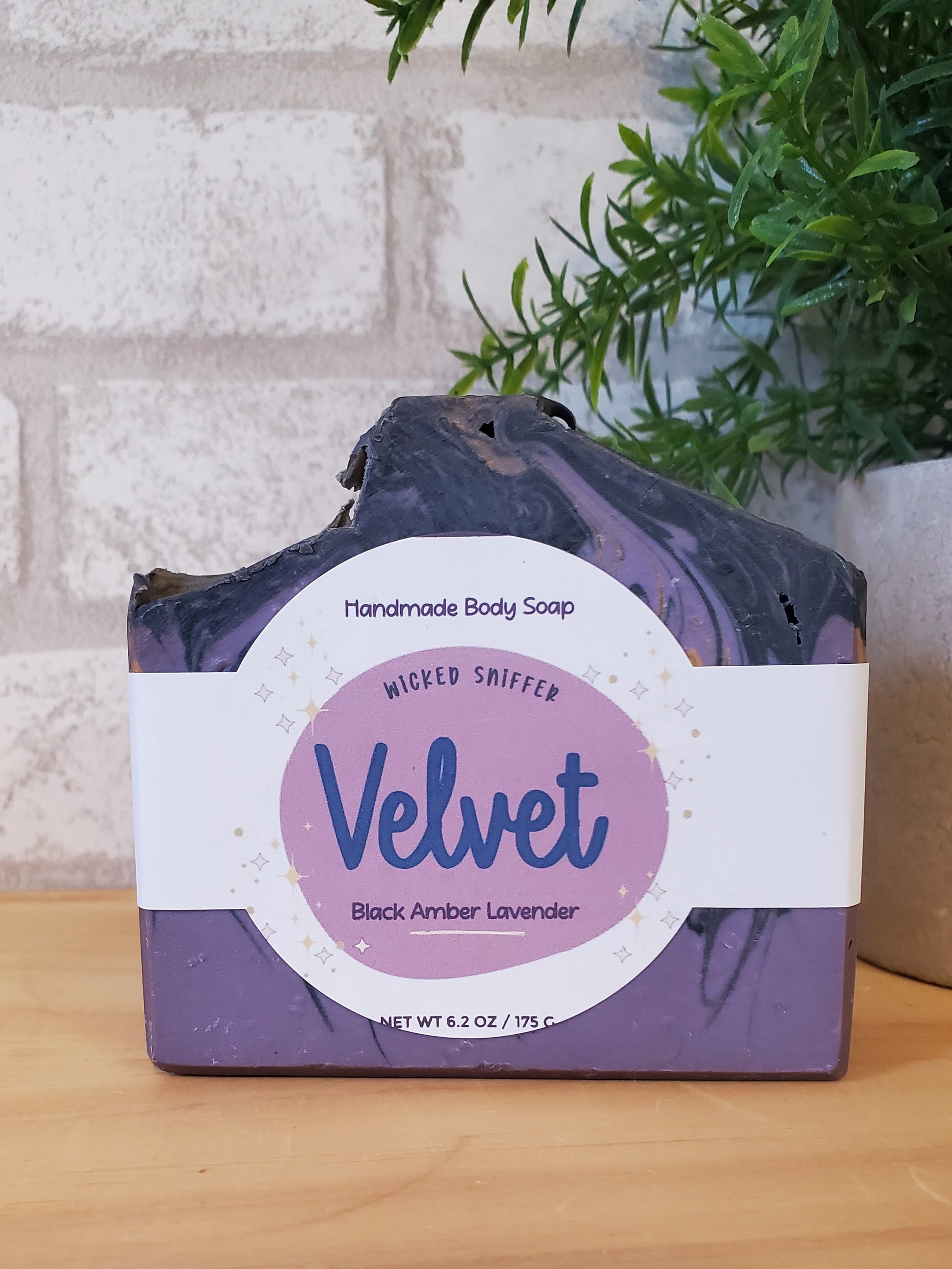 Bar of soap with a purple and white label on a wooden surface