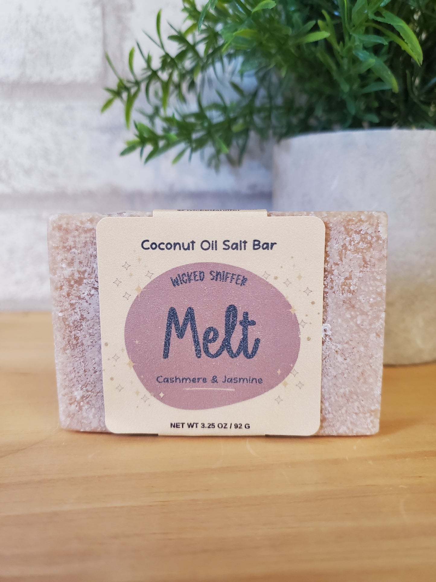 Coconut oil salt bar with 'Melt' branding on a wooden surface