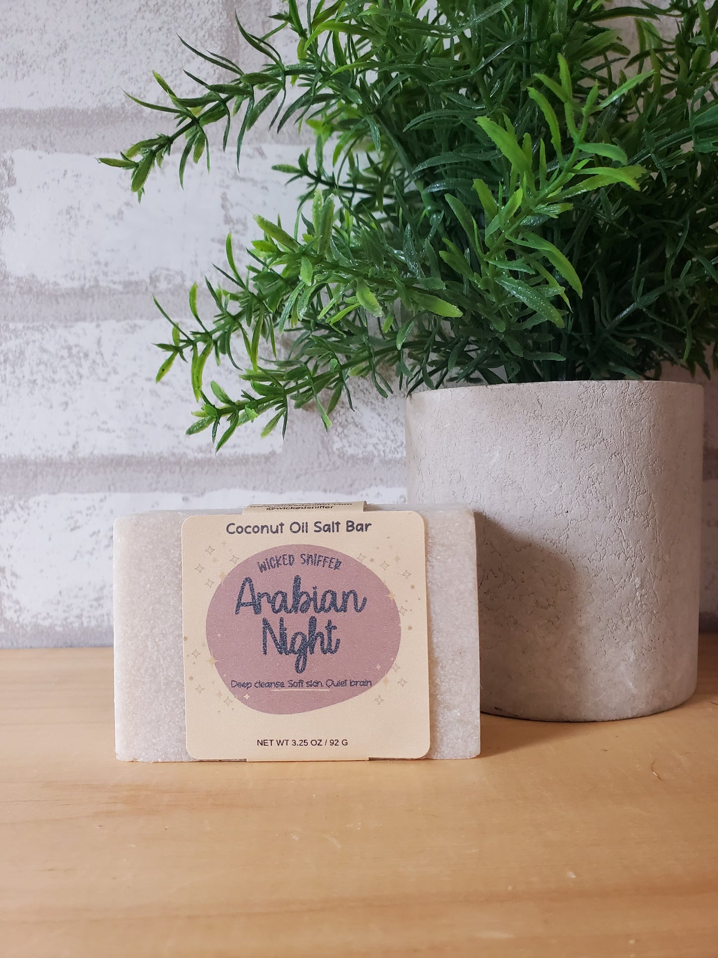 Coconut oil soap bar with a plant on a wooden surface