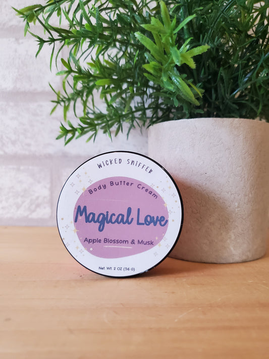 Jar of 'Magical Love' body butter cream with a plant on a wooden surface