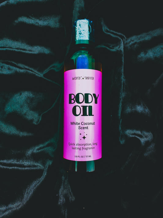 Bottle of body oil with a pink label on a dark textured background