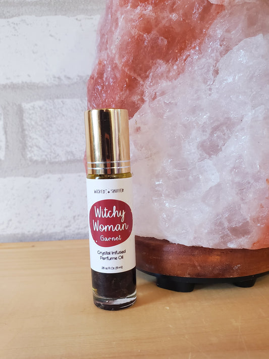 Small bottle with gold cap and red label on a textured surface