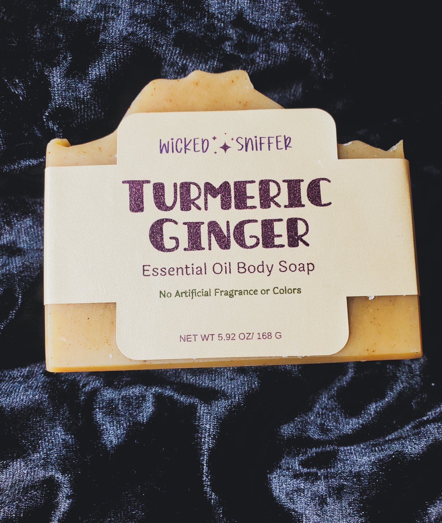 Turmeric Ginger essential oil body soap with 'Wicked Sniffer' branding on a dark textured background